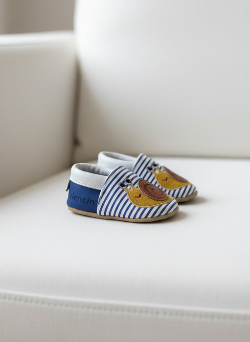 chausson bébé en cuir sur canapé modele marinière 